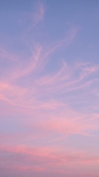 Soft sunset sky in periwinkle and rose with wispy cirrus clouds