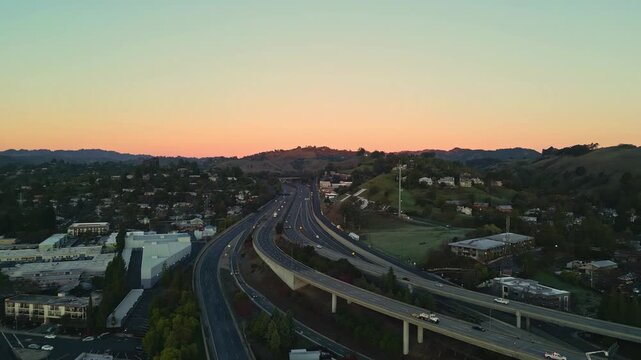 Aerial view of a highway interchange at sunset with rolling hills in the background in Walnut Creek, California, United States.