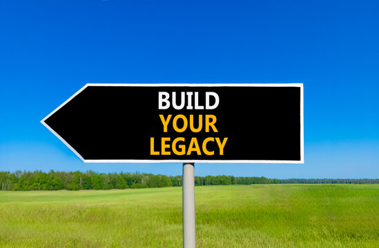 Build your legacy words symbol. Concept words Build your legacy on beautiful black road sign. Beautiful blue sky green grass background. Business build your legacy concept. Copy space.