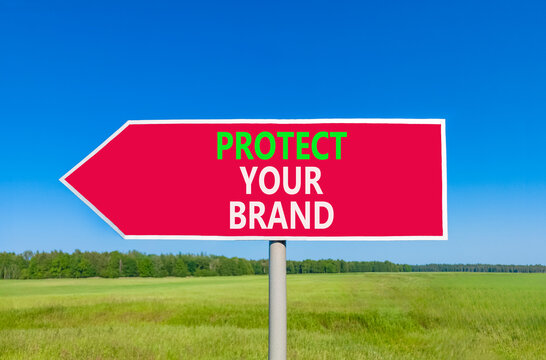 Protect your brand words symbol. Concept words Protect your brand on beautiful red road sign. Beautiful blue sky green grass background. Business and protect your brand concept. Copy space.