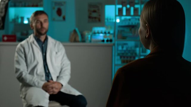 Young adult Caucasian woman consulting Caucasian male pharmacist over shoulder in pharmacy store during interview, gesturing. Perfect for healthcare marketing and medical promo videos