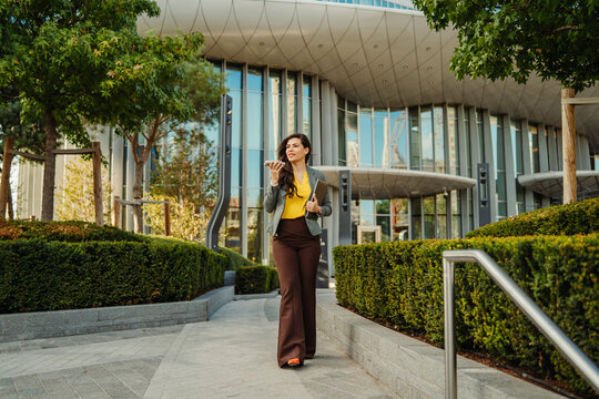 Businesswoman walking in city speaking on phone