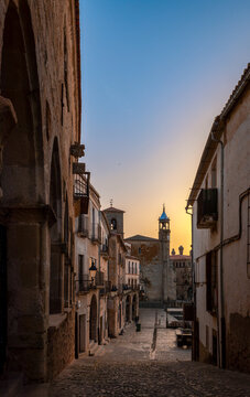 Street in the old town of Trujillo, C&aacute;ceres, Spain, at dawn with streetlight lighting and the church in the background