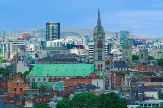 View of St. Patrick's Cathedral with its distinctive green roof and tall spire, set against the modern and historic skyline of Dublin, County Dublin, Ireland.