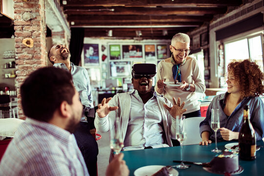 Friends laugh as man tries vr headset at party