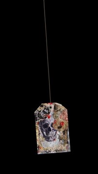 An animated Halloween themed hanging element in a paper-collage style that gently sways on a loop and features spooky ephemera details.
