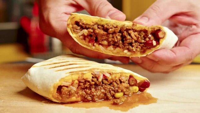 4K Video of hands holding freshly prepared stuffed pita bread filled with minced meat and vegetables, showcasing a savory meal.