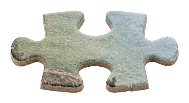 A weathered jigsaw puzzle piece with muted coastal imagery isolated on a black background