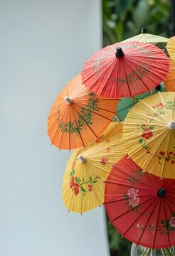 asian culture and travel, colorful paper umbrellas with floral patterns for cocktails and traditional decor in a bright outdoor garden setting