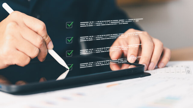 Close-up person using stylus pen touching tablet digital checklist task list. Concept business management project planning corporate productivity workflow success schedule document