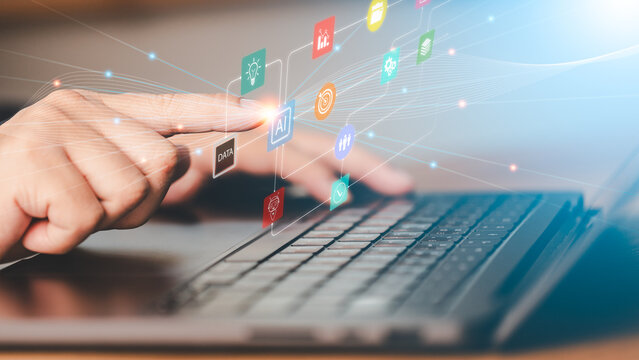 Close up of person touching laptop keyboard with digital AI network interface and icons. Concept of artificial intelligence technology, smart business automation and futuristic digital tech