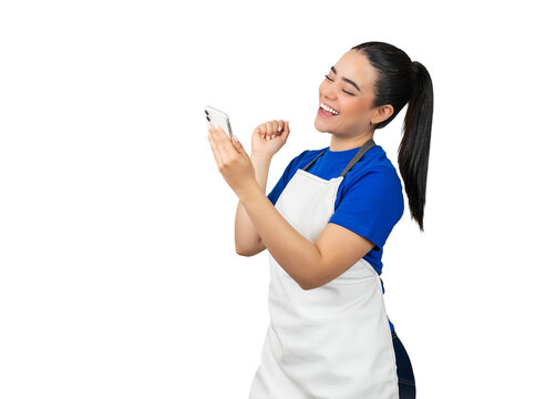 Cheerful latina service worker woman in apron celebrating success while looking at smartphone, transparent background