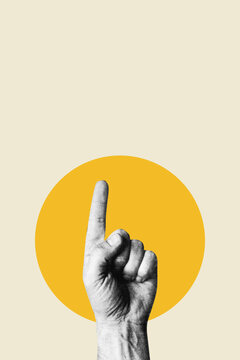 Hand pointing index finger upward against yellow circle background