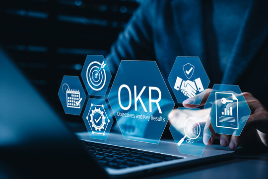 Objectives and key results concept. Business professional using laptop and OKR for goal setting, performance tracking, measurable outcomes, strategic alignment, organizational productivity management