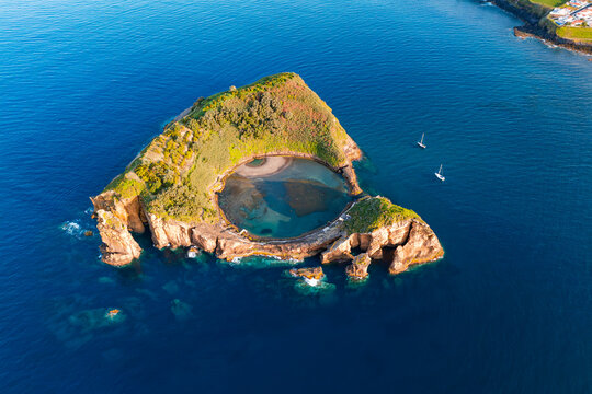 Crater lagoon near Sao Miguel in Azores, Portugal. Aerial of Vila Franca do Campo Islet with narrow ocean inlet and surrounding volcanic cliffs