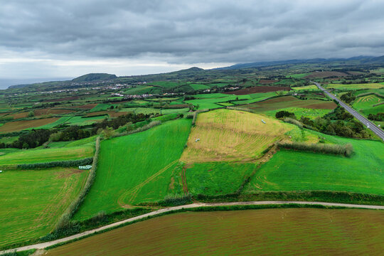 Aerial wide view of agricultural landscape on Sao Miguel Island, Azores, with green fields, farmland patterns and hills