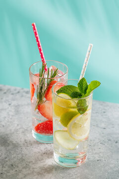 Two fresh non alcoholic drinks with strawberry and lemon on blue background
