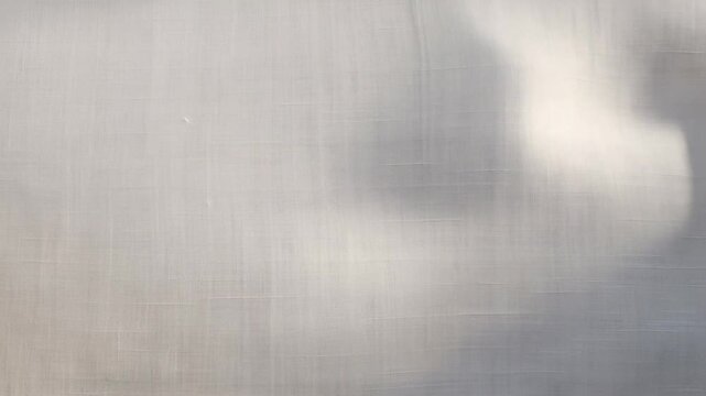 Soft daylight and diffused shadows drift across a pale textured surface. Wellness promotion, minimal branding, and interior design presentation.