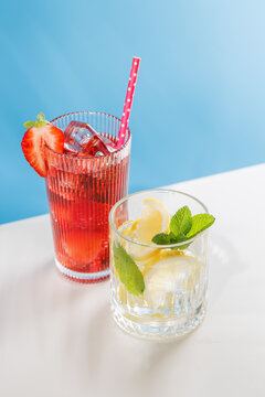 Fresh strawberry and lemon non alcoholic drinks with mint on blue background