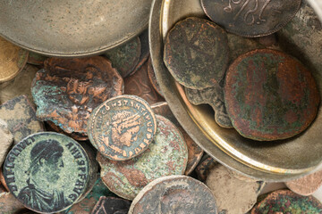 Ancient Roman bronze coins collection with emperor portraits and patina. Roman bronze coins with visible emperor portraits and inscriptions. Weathered surfaces © ArieStudio