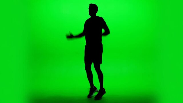 Man silhouette doing jumping jacks exercise on green screen background, fitness workout chroma key footage for gym videos, health apps, training programs and new year resolution projects
