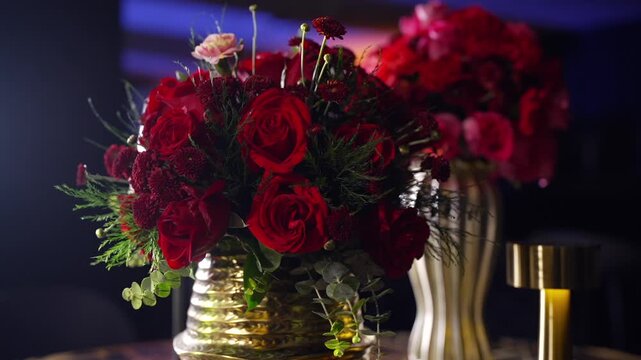 Luxury red roses floral arrangement in golden vases on a stylish table for elite event and wedding design