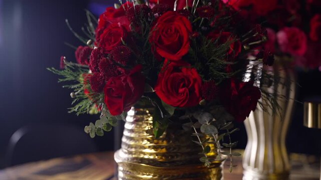 Luxury red roses floral arrangement in golden vases on a stylish table for elite event and wedding design