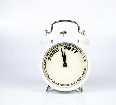 Alarm clock showing 2026 replaced by 2027 text written on white background.
Good bye 2026 - 2027 happy New Year coming concept.
