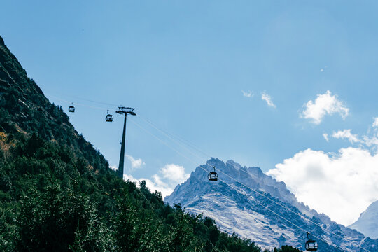 View of cable cars moving along a mountain slope with snow-capped peaks in the background at Ala Archa National Park, Bishkek, Chuy Region, Kyrgyzstan.