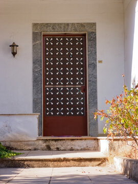 Traditional entrance door of an old house with wrought iron grille design and marble trim in Athens, Greece.