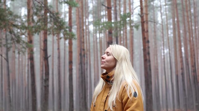 Woman Taking Deep Breaths in a Foggy Autumn Pine Forest. Mindfulness, Nature Therapy and Mental Wellbeing.