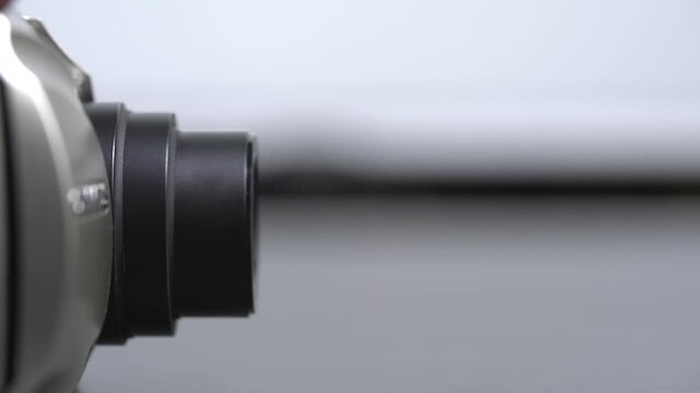 The mechanism of a retractable zoom lens in action on an old film camera from the 1990s