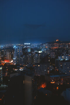 Illuminated city skyline at dark night. Urban cityscape overview with glowing lights