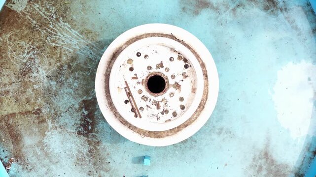 Aerial view of a weathered circular industrial component with rusted bolts and textured surface in Araras, Sao Paulo, Brazil.