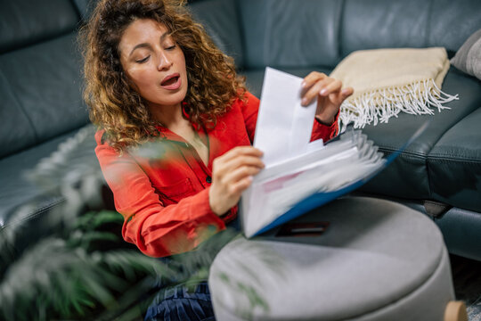 Woman looking through documents inside a blue binder file folder