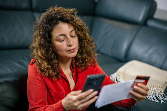 Focused woman entering credit card information on mobile phone
