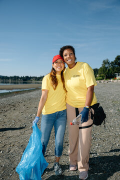 Volunteers cleaning beach together, smiling and helping community