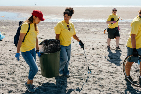 Volunteers cleaning beach litter on sunny shore