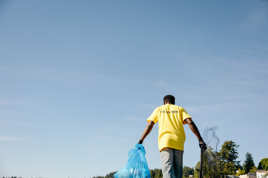 Volunteer beach cleanup under clear blue sky
