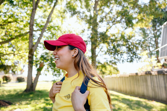 Young woman smiling with backpack in sunny park
