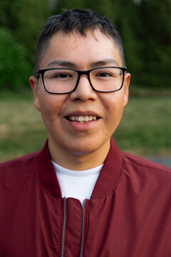 Candid smiling teen portrait with glasses outdoors, casual jacket