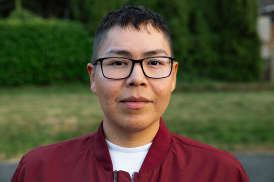 Candid outdoor portrait of a young person with glasses