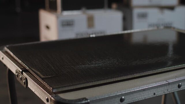 Shifting camera and lighting revealing black case on stand in studio, showing latches and hardware