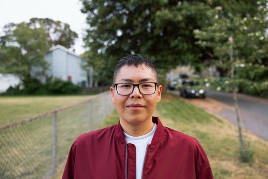 Candid portrait of a young adult with glasses in a neighborhood