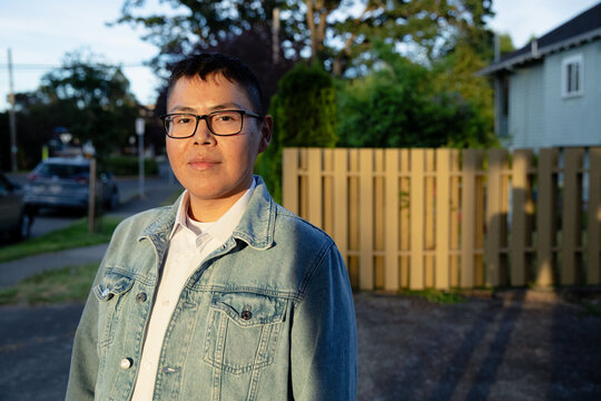 Candid outdoor portrait of a young person in denim jacket