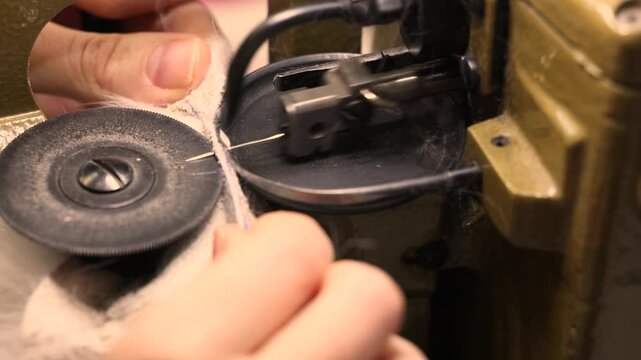 Hands guide thread through a vintage sewing machines bobbin mechanism