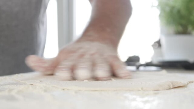 Senior Bakery Chef Rolling Dough on the Kitchen Table. Man in the Kitchen Making Dough for Traditional Homemade Pizza and Pastry.