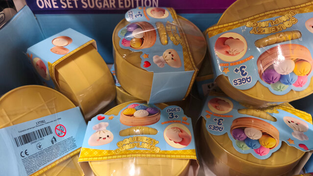 Kyiv, Ukraine, October 19, 2026. A close-up view of trendy, squishable anti-stress toys shaped like dumplings. bright yellow containers, collectible stress relief figures for sensory play.