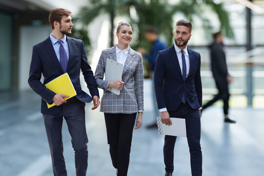 businesspeople group walking at modern bright office interior.