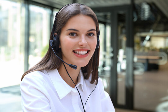 Female customer support operator with headset and smiling.